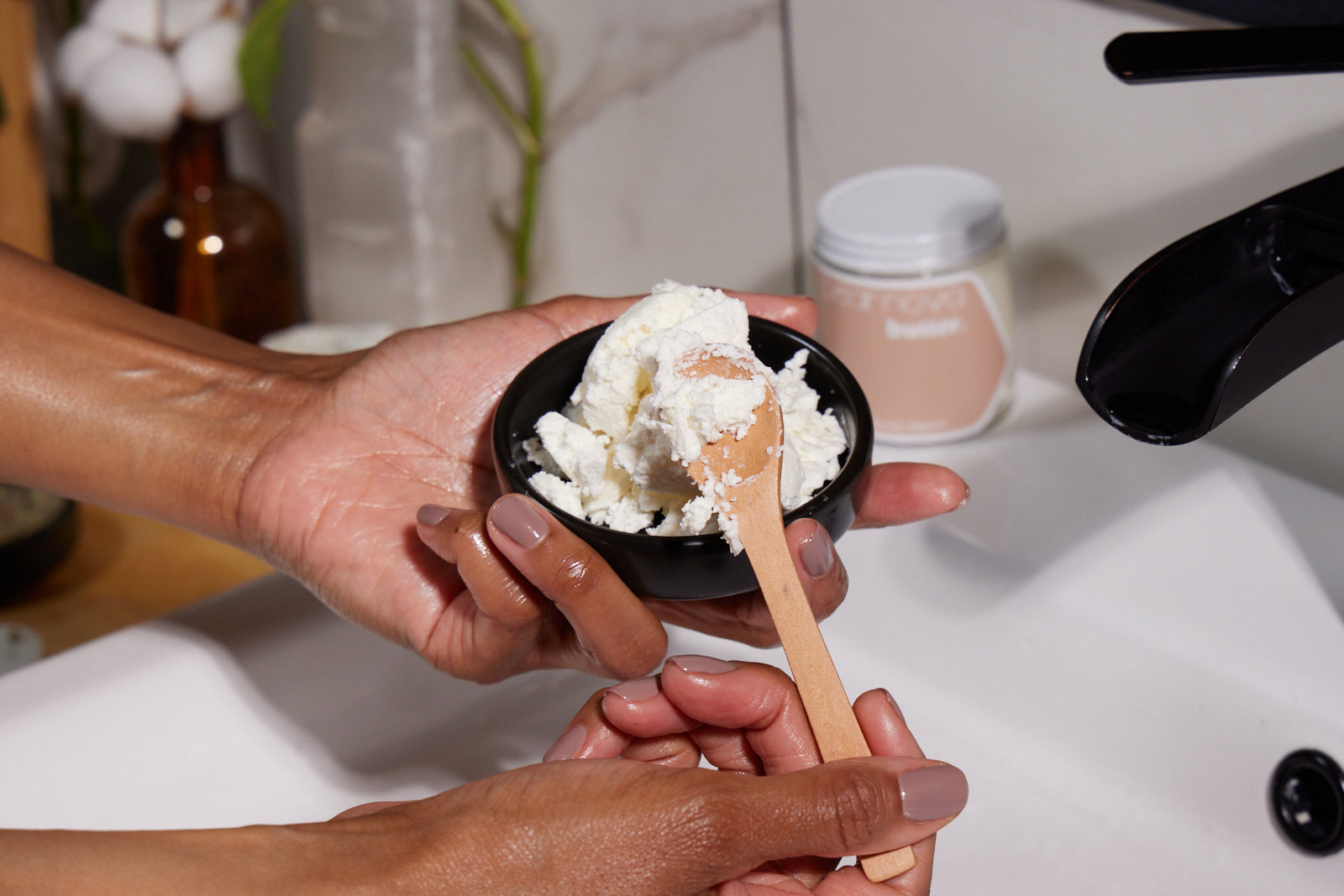 moisturized brown skin hand model holding a dish filled with Butter scooping out a spoonful of Butter