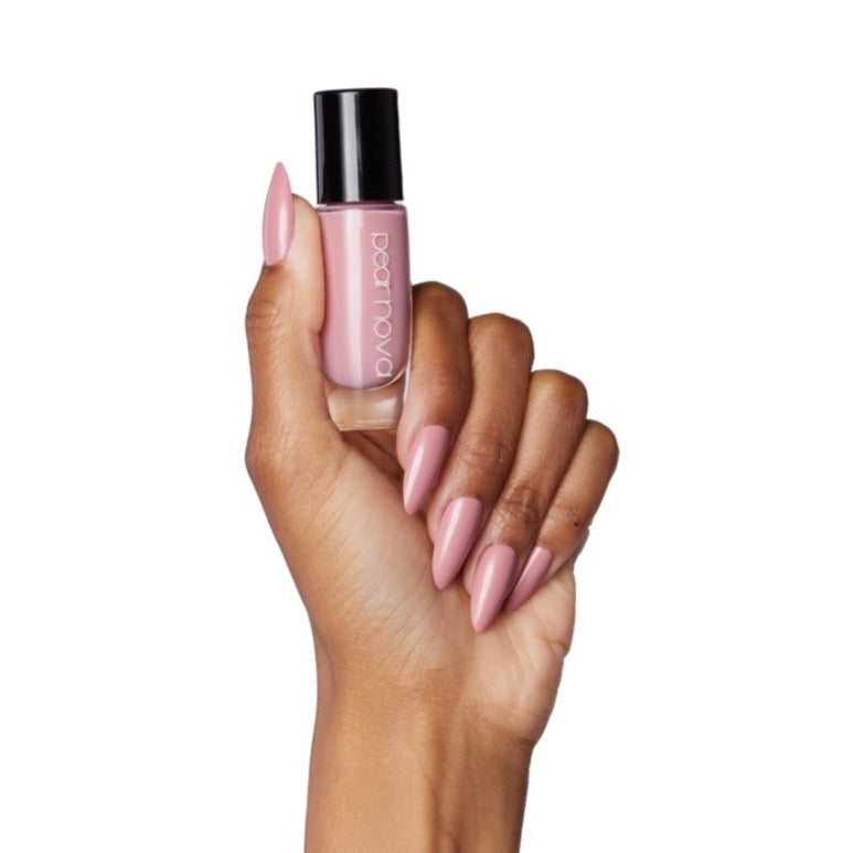 brown skin hand model holding bottle of nail lacquer with almond shaped painted nails