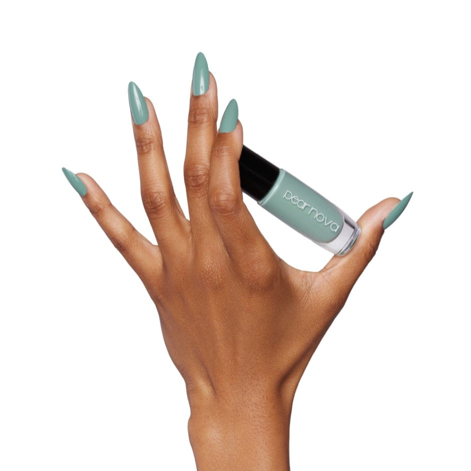 brown skin hand model holding bottle of nail lacquer with almond shaped Aloe-Ha painted nails 