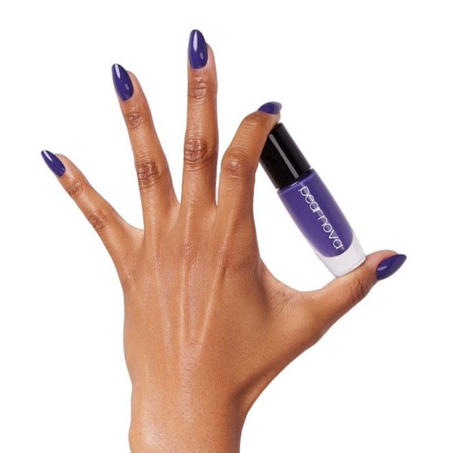 brown skin hand model holding bottle of nail lacquer with almond shaped violet painted nails in Beaucoup Bougie